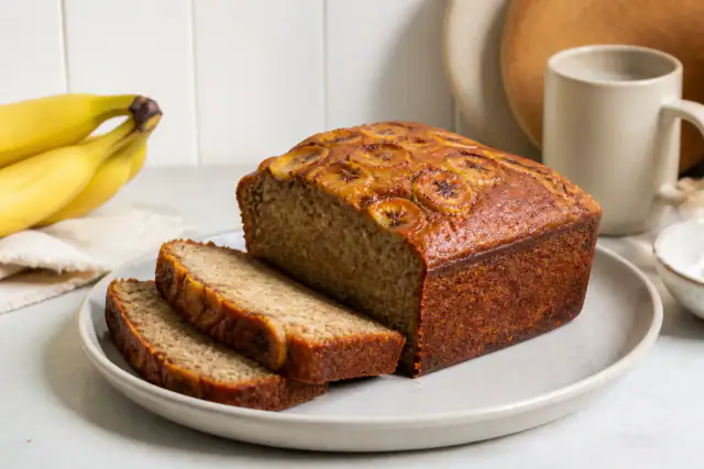 Banana bread moelleux tranché avec banane caramélisée sur le dessus