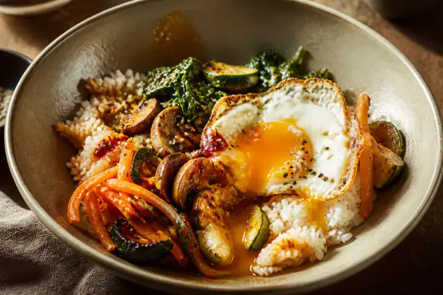 Bibimbap végétarien avec riz, légumes colorés, champignons et œuf au plat