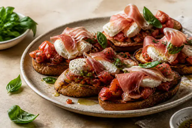 Bruschettas grillées avec jambon cru, dés de tomates, mozzarella et basilic
