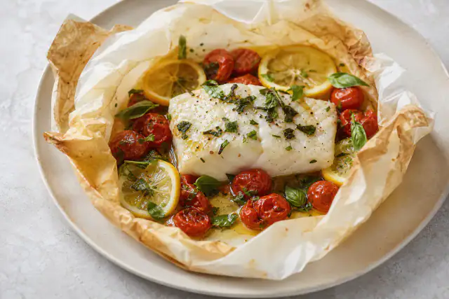 Dos de cabillaud cuit en papillote avec tomates cerises, citron et basilic