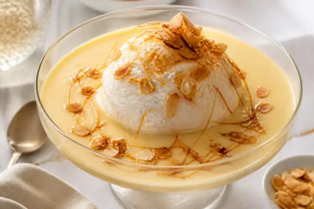 Île flottante avec blancs cuits doucement, crème anglaise vanillée, caramel et amandes