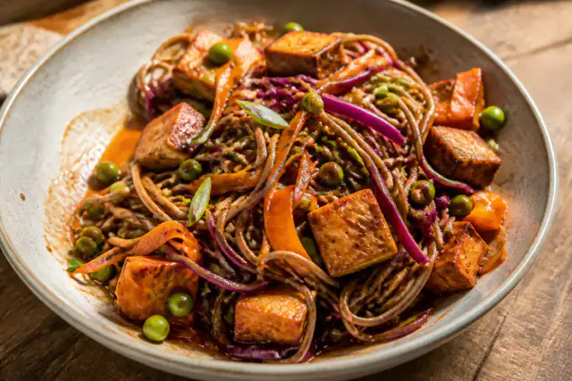 Nouilles soba au tofu doré avec carottes, chou rouge et petits pois