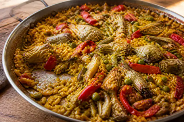 Paella végétarienne dorée aux artichauts, poivrons, haricots verts et petits pois