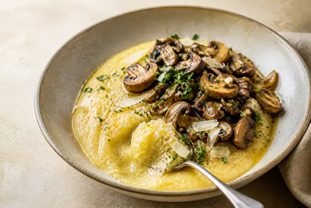 Polenta crémeuse au Parmesan garnie de champignons dorés et persil