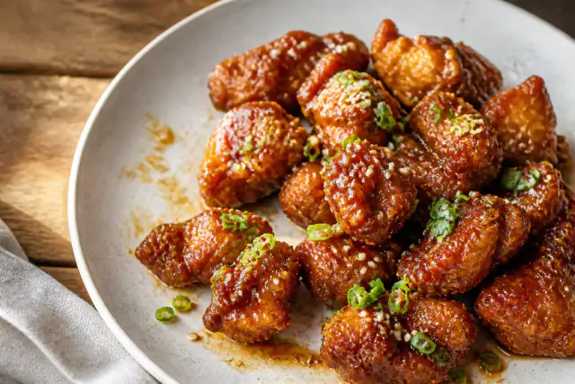 Poulet Général Tao croustillant et brillant avec cébettes et graines de sésame