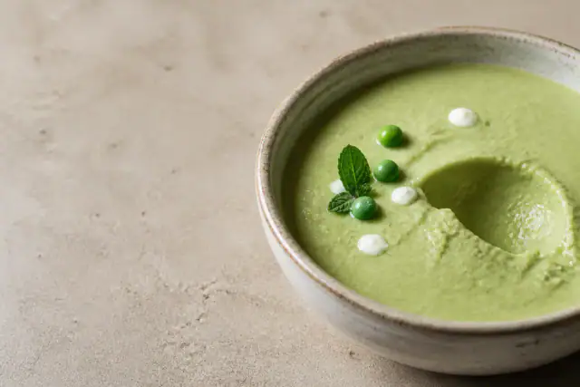 Velouté froid vert vif de petits pois avec menthe fraîche et filet de yaourt